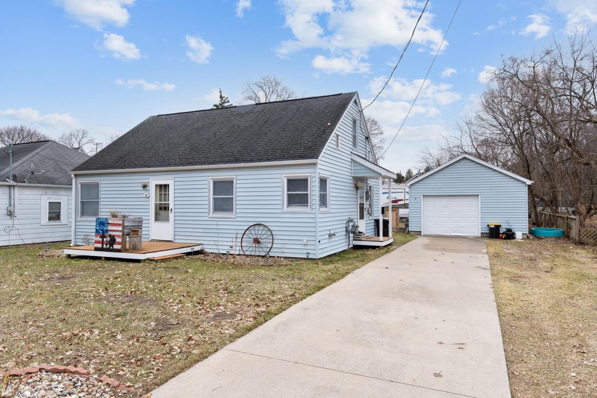 White one-story home with a side deck and a detached garage