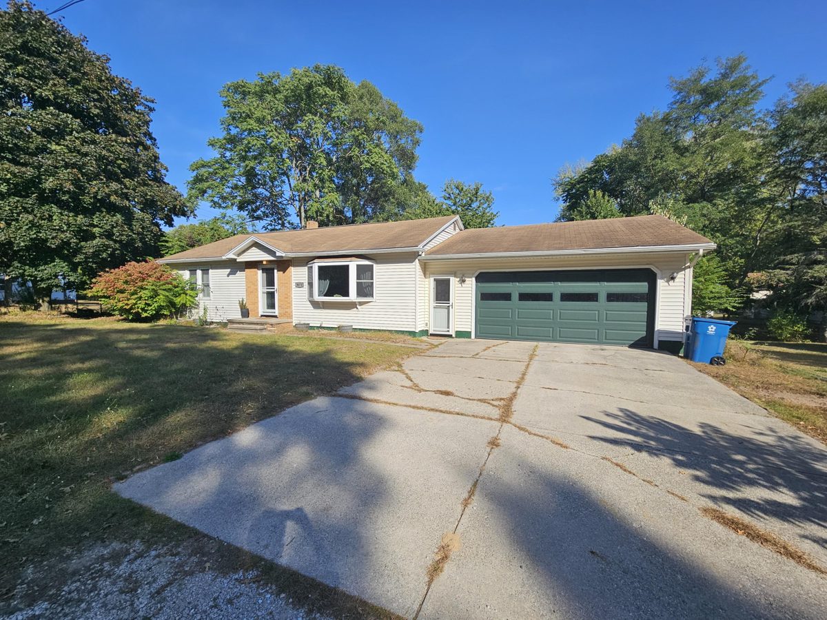 Ranch home with an attached garage and a long concrete driveway